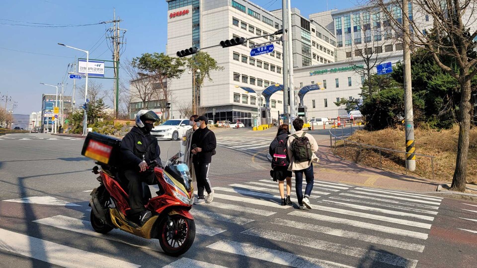 23일 오후 춘천 강원대학교병원 앞 사거리. 보행자들이 오토바이를 피해 횡단보도를 건너가고 있다. (사진=김준엽 기자)
