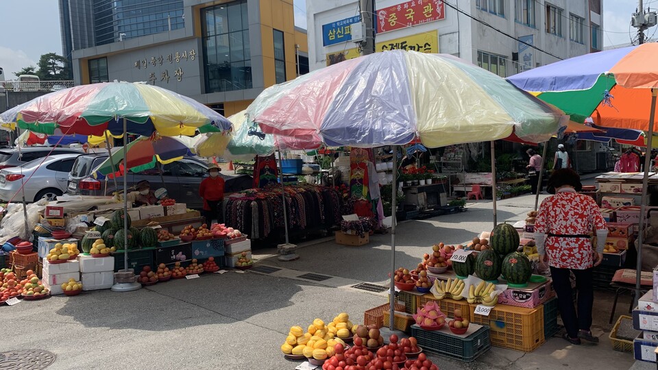 춘천중앙시장 인근 과일가게 상인들이 그늘막에 의존해 폭염을 피하고 있다.(사진=정원일 기자)