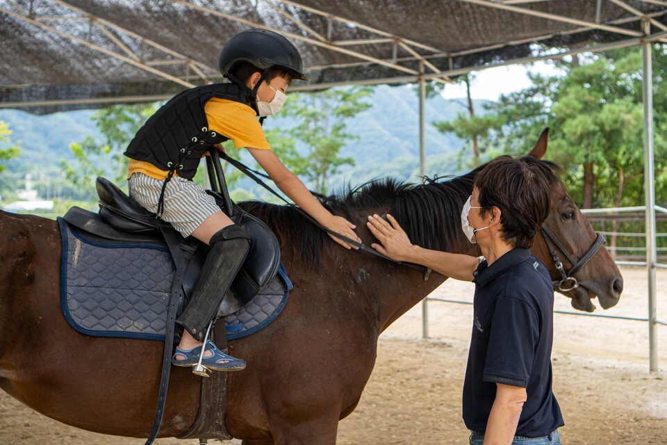 재활승마에 참여한 한 어린이가 말과의 접촉을 통해 교감하는 모습. (사진=서충식 기자)