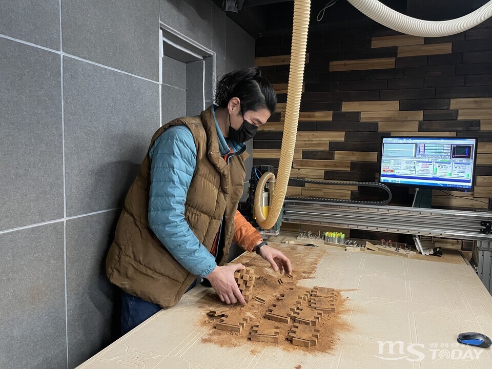김승윤 짙은목공방 대표가 CNC 시스템을 통해 원목 펜꽂이를 제작하고 있다. (사진=권소담 기자)
