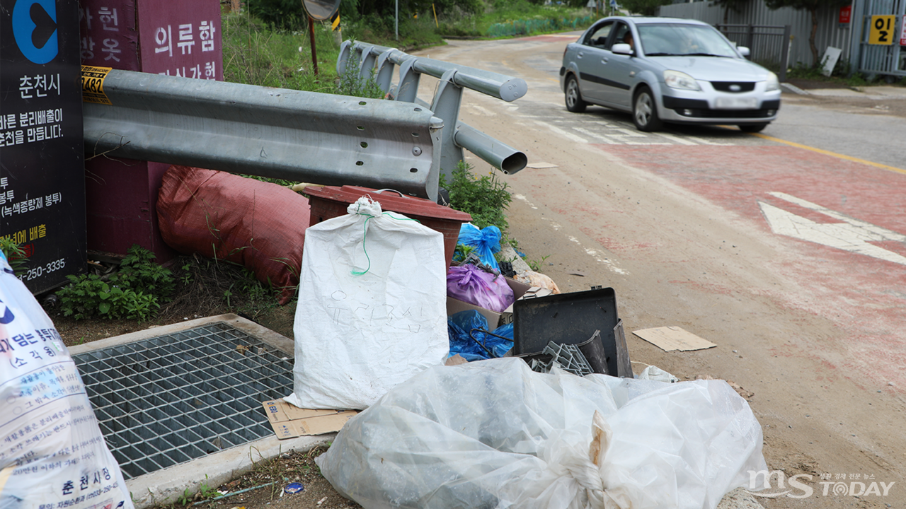 춘천 만천리 도로에 설치된 빗물받이 위에 쓰레기가 가득 쌓여 있다. (사진=박지영 기자)