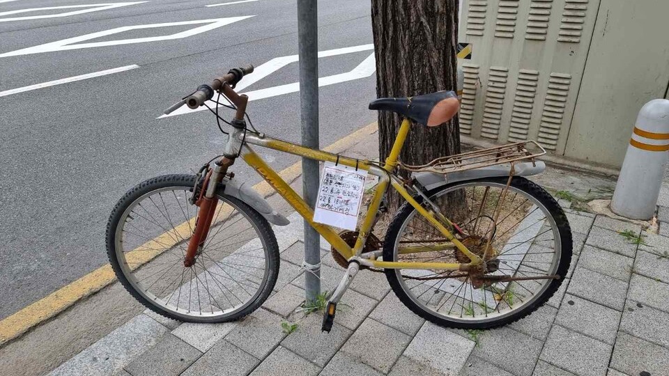 춘천 온의동 부근 버려진 자전거에 이동요청 스티커가 부착돼 있다. 춘천시는 이 같은 방치 자전거를 수거해 수리, 기증하는 사업을 진행하고 있다. (사진=춘천시 제공)