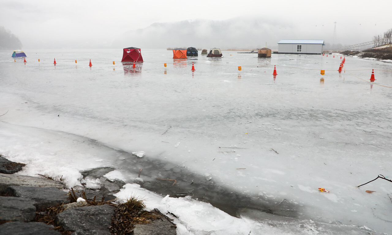 춘천시 송암동 의암호 수변, 포근한 날씨로 얼음판이 녹고 있는 가운데 설치된 빙어 낚시꾼들의 텐트가 위태롭게 보인다. 