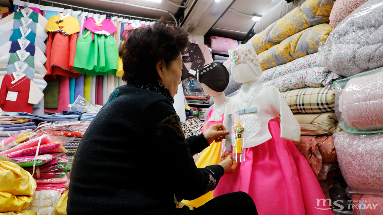 춘천 중앙시장의 한복 전문점에서 상인이 고운 빛깔의 한복 매무새를 가다듬고 있다. (사진=박지영 기자)
