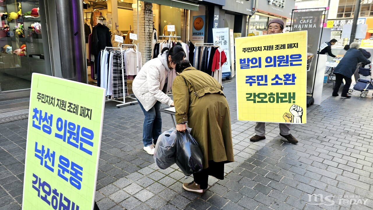 춘천시민이 춘천시장의 재의요구권 행사를 촉구하는 서명운동에 참여하고 있다. (사진=한승미 기자)